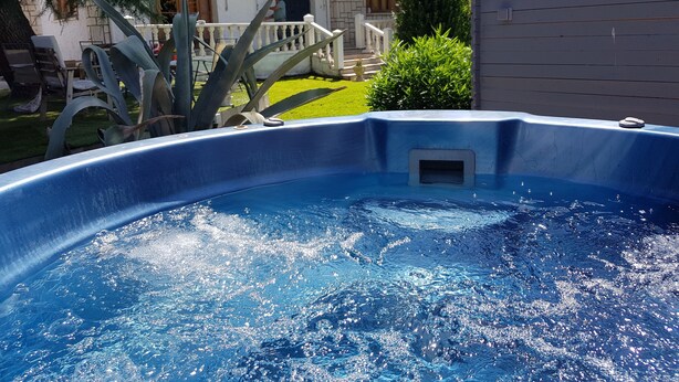 Una piscina con vistas despejadas a una casa al fondo.