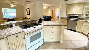 A kitchen with a stove, microwave, and dishwasher. - EASY 5-Min Walk to Beach Path! NEW Saltwater Pool & Spa, Steps to Dining & Shops (Marco Island)