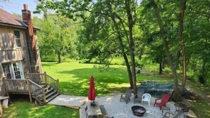 A backyard with a fire pit, outdoor furniture, and a covered seating area. - Fish ,Relax, Repeat.  (Conneaut)