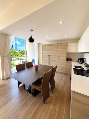 Uma cozinha moderna com área de jantar, armários de madeira e vista para o exterior.