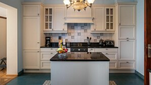 A kitchen with white cabinets, a black countertop, and a central island with fruit. - Beautiful private villa for 6 people with WIFI, TV and terrace (Mol)