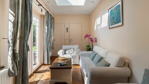 A spacious living room with a high ceiling, large windows, and a skylight. There are two white sofas, a coffee table, and a potted orchid. - Beautiful private villa for 6 people with WIFI, TV and terrace (Mol)
