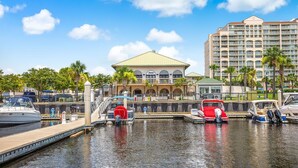 A marina with boats docked, a hotel with a distinctive roof, and a large building in the background. - 🏝 Barefoot Landings in N Myrtle Beach-2 Resort Pools/ Golf/  8 Mins to Beach 🏝 (North Myrtle Beach)