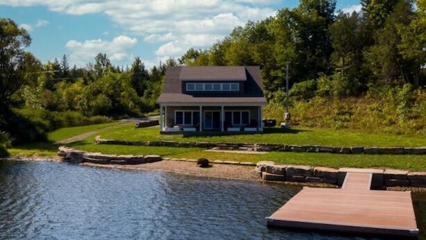 A house by a lake with a dock. - Peaceful Private Waterfront Home (Redwood)