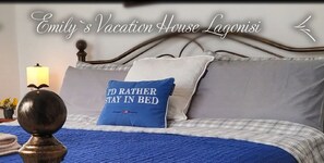A neatly made bed with a blue blanket and pillows, including one with a political message. - House Sleeps 4 with Pets (Kalivia Thorikou)