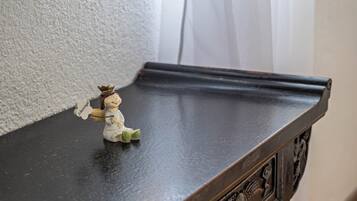 Une petite figurine posée sur une table en bois foncé.