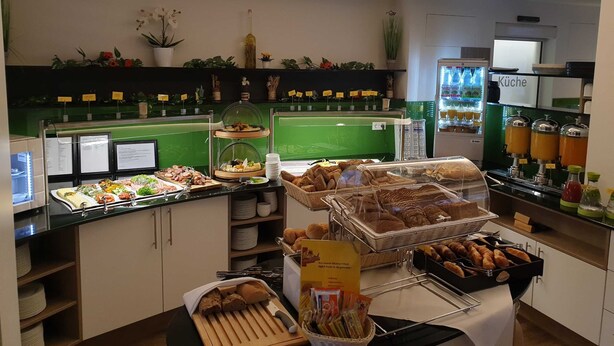 A buffet area with various food options, including bread, pastries, and a beverage station. - Single room in category M - Hotel Am Kaisersaal (Erfurt)