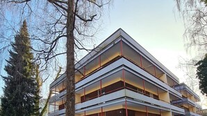 A multi-story building with balconies, surrounded by trees and snow on the ground. - Apartment Sophia, 60sqm, 1 bedroom, balcony with mountain view (Bad Reichenhall)