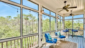 A covered outdoor area with large windows, ceiling fans, and outdoor seating. - Beach Home with Gulf Views! Steps to Heated Community Pool Minutes to 30A's newest beach access! (Santa Rosa Beach)