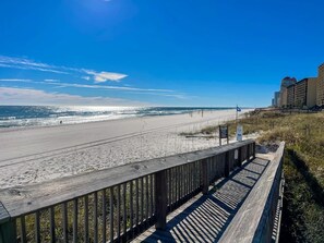 A beach with a wooden boardwalk, ocean view, and a hotel in the background. - Seaside Beach & Racquet 4608 Views & Chill Hues (Orange Beach)