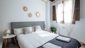 Une chambre à coucher bien rangée, avec un lit, des tables de chevet et des éléments décoratifs sur les murs.