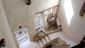 A view of a stone staircase leading to a lower level, with a metal gate and a small window with bars. - "l'escapade"... Entre Lacs, mer et Montagnes (Hérépian)