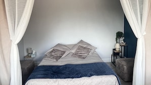 A bedroom with a bed, two bedside tables, a nightstand, and a wall-mounted shelf. - T1 on the shores of Lake Christus in Saint Paul Les Dax (Saint-Paul-lès-Dax)