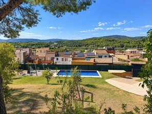 A residential area with houses, a swimming pool, and a view of the hills.