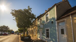 A row of traditional terraced houses with a sign indicating a guest house. - Irvine Riverside Guesthouse (Irvine)