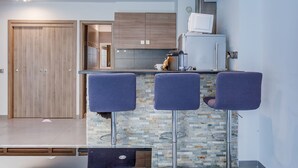A modern kitchen with a bar area, wooden cabinets, and a tiled backsplash. - SUEDE 2 AP4208 By Riviera Holiday Homes (Niza)