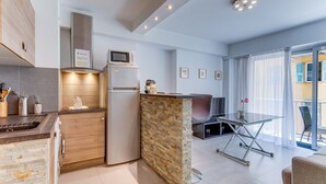 A modern kitchen with a built-in microwave, a refrigerator, and a stone accent wall. - SUEDE 2 AP4208 By Riviera Holiday Homes (Niza)