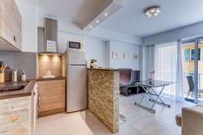 A modern kitchen with a built-in microwave, a refrigerator, and a stone accent wall. - SUEDE 2 AP4208 By Riviera Holiday Homes (Niza)