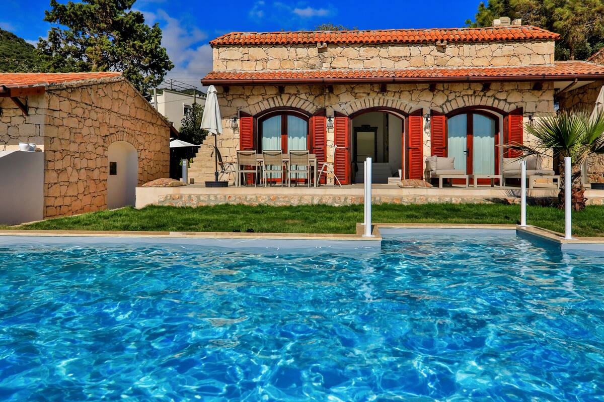 A stone building with a swimming pool in front.