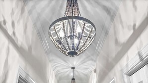 A hallway with a large, ornate chandelier hanging from the ceiling.
