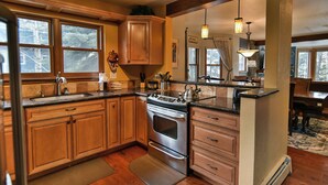 A kitchen with wooden cabinets, a stainless steel stove, and a large window. - Ridge Retreat Breckenridge Townhome: Great Location, Views (Breckenridge)