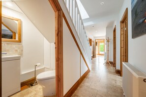 Een moderne badkamer met toilet, wastafel en spiegel.