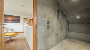 Enjoy a refreshing shower in this bathroom featuring a rain showerhead and a radiator for added comfort.