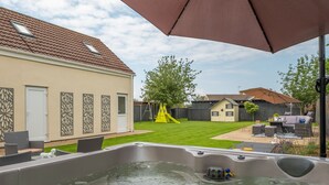 A backyard with a hot tub, outdoor furniture, and a yellow slide. - Grace Cottage, Heacham, Norfolk (Heacham)