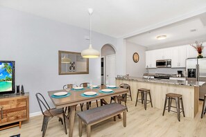 A modern kitchen with white cabinets, a microwave, and a refrigerator. - Luxurious 3BD Home Close to Convention Center and Themed Parks! #3vc209 (Orlando)