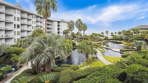 Ein Resort mit Pool, Palmen und einem Gebäude mit Balkonen.
