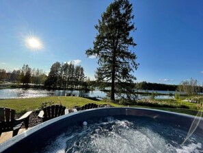 A hot tub with a view of a lake and trees.