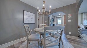 A dining area with a round table, four chairs, a chandelier, and a framed inspirational quote on the wall. - The Suite in a carriage house in Kennett Square (Kennett Square)
