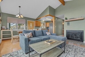 A living room with a sectional sofa, a coffee table, and a fireplace.