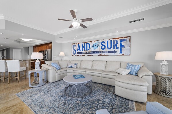 A modern living room with a sectional sofa, a round coffee table, and a decorative rug.