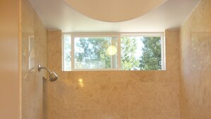 Un baño con bañera, ducha y ventana.