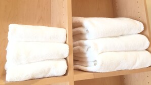 Un estante de madera con toallas blancas dobladas ordenadamente.