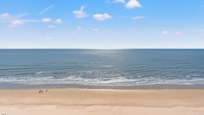 A beach with a clear sky and calm sea.