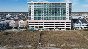 A large hotel with multiple floors, a parking garage, and a swimming pool.