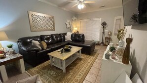 A living room with a black leather sofa, a wooden coffee table, and a patterned rug. - Townhome:  2 Bedrooms, 2.5 Baths, Close to Campus (Oxford)