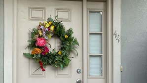 A beige front door with a decorative wreath, a small potted plant, and a mailbox. - Townhome:  2 Bedrooms, 2.5 Baths, Close to Campus (Oxford)