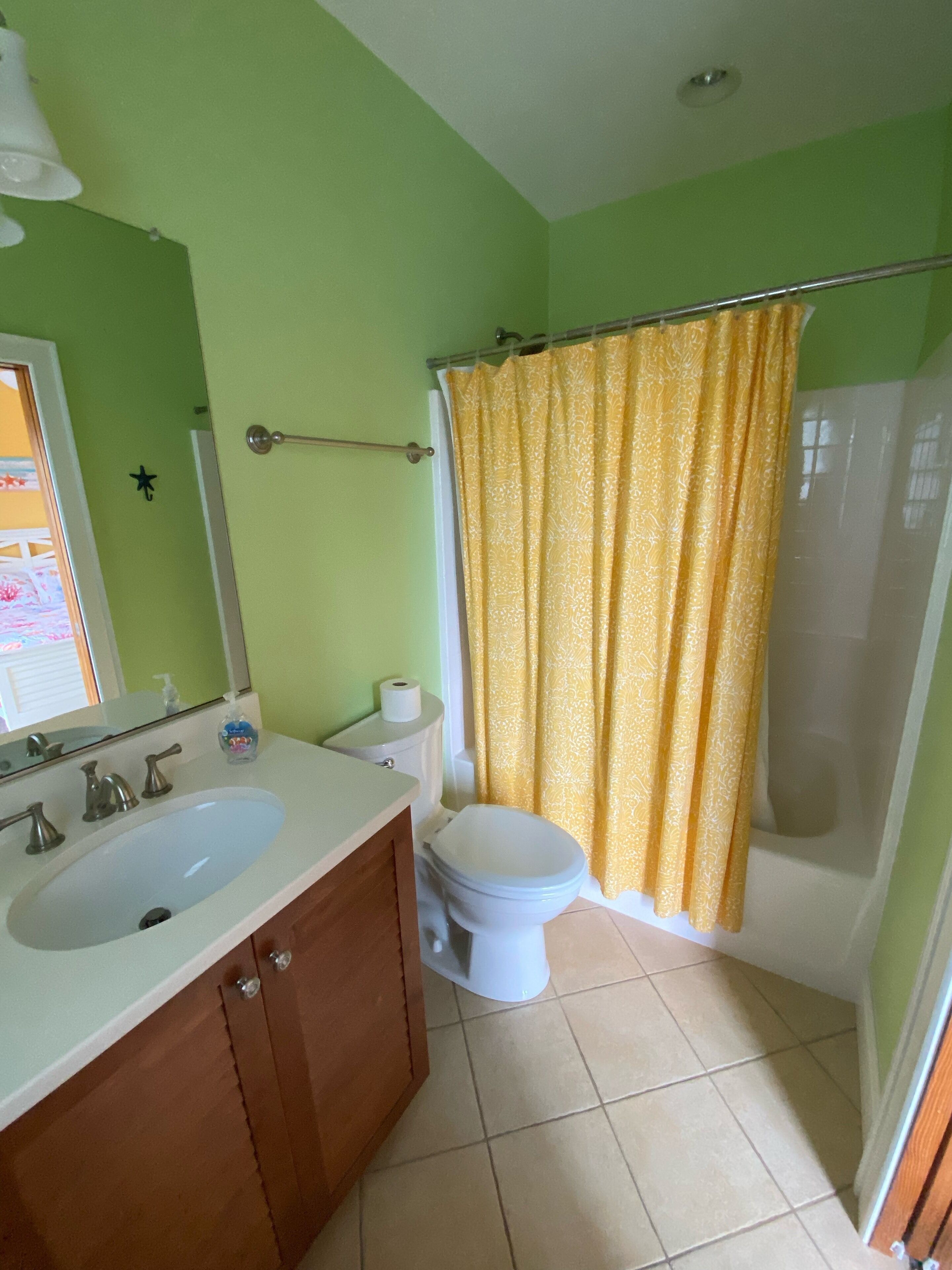 A bathroom with a sink, toilet, and shower curtain.