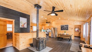 Ein Holzblockhaus-Interieur mit Küche, Essbereich und Kamin.