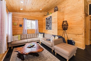 A cabin interior with a wooden ceiling, a sofa set, a coffee table, and a lamp. - Grand Lake Getaway Near RMNP + Deck with Views! (Grand Lake)