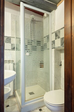 Een douche, een haardroger, een bidet, handdoeken