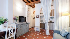 Una sala de estar acogedora con una televisión, una mesa de comedor y un sofá.