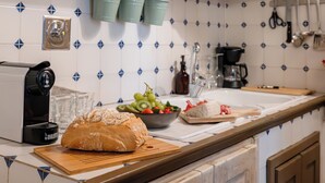 Una cocina con hogaza de pan, frutero y cafetera.
