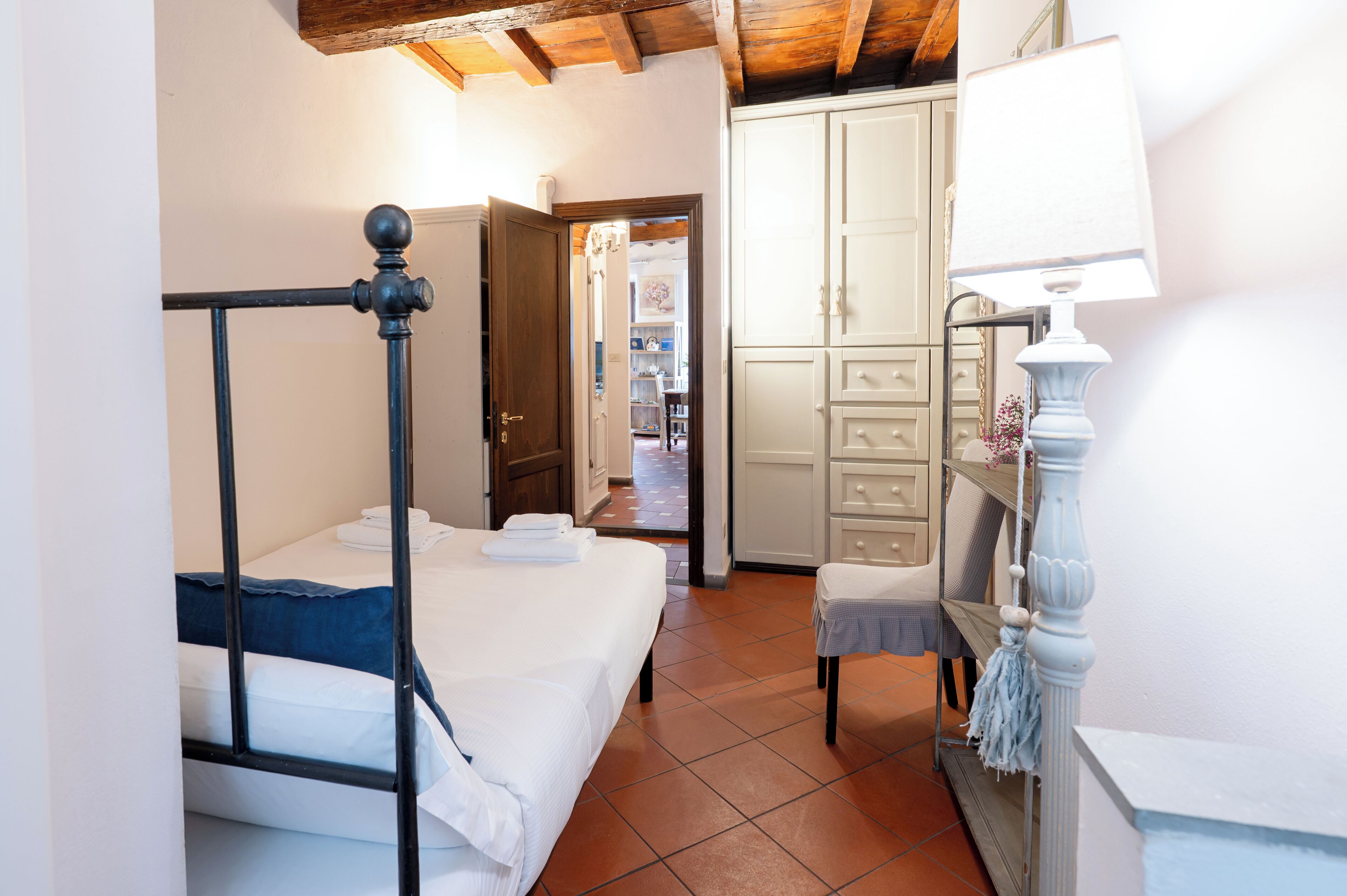 Ein Schlafzimmer mit Bett, Nachttisch, Lampe und Kleiderschrank.