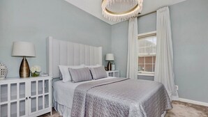 A bedroom with a large bed, a nightstand, a lamp, and a window with curtains. - Private In-law suite in upscale neighborhood (Huntsville)