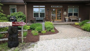 Un bâtiment à l’extérieur brun, avec une porte d’entrée et un panneau indiquant les directions pour se rendre au « Bear Left Garden Center » et au « Bear Right Hearts Desire Parking ».