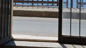 Une vue à travers une fenêtre ornée d’une rambarde en métal, donnant sur une étendue d’eau.